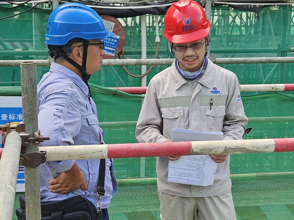 1-2、王淙(右)在工程现场与业主交流(1).jpg